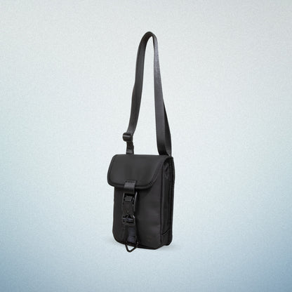 Side view of a black WAVEIT eco-friendly crossbody bag with a buckle closure, displayed on a light blue gradient background.