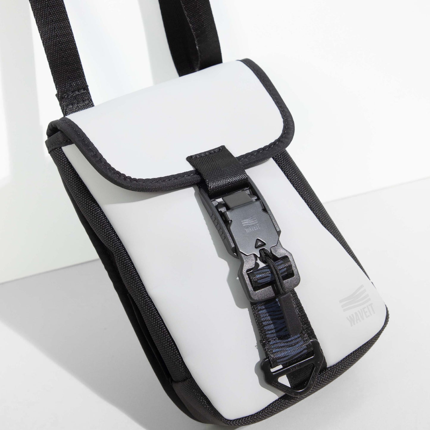 Close-up of white WAVEIT eco-friendly crossbody bag with secure buckle and black trim.