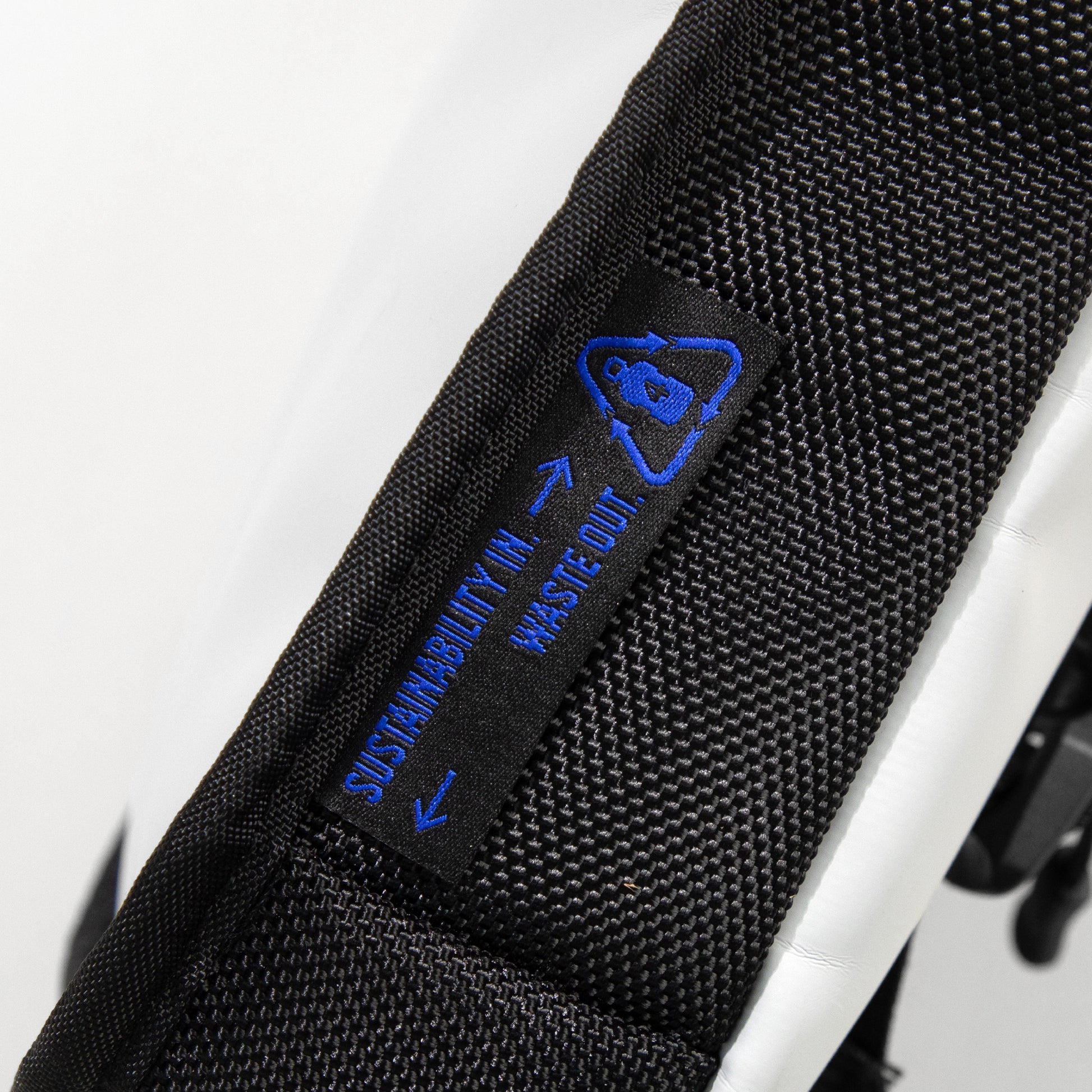 Close-up of WAVEIT backpack with a 'Sustainability In, Waste Out' label, highlighting the eco-friendly design.