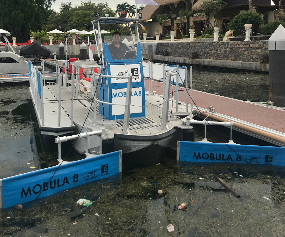 Boat from the Indonesia Project, labeled Mobula 8, docked and ready for ocean cleanup efforts, highlighting the initiative to reduce marine pollution.